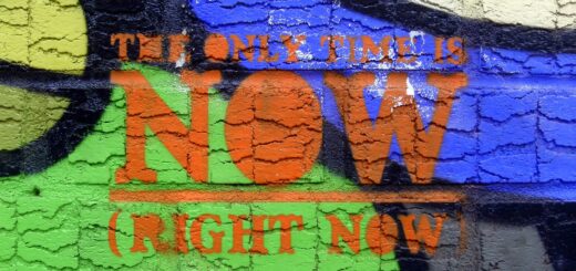 Bunt besprühte Mauer, darauf Text: The only time is now (right now)